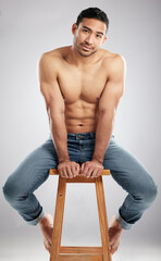 Fitness is my passion. Studio shot of a handsome young man showing off his muscular body while sitting on a chair against a grey background.
