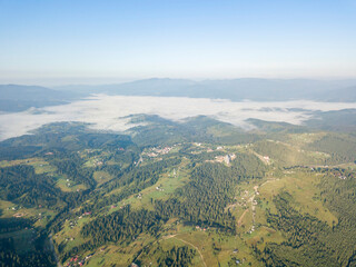 Obraz premium High flight in the mountains of the Ukrainian Carpathians. Fog in the valley. Aerial drone view.
