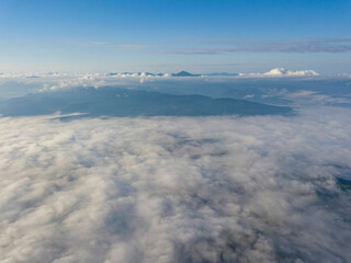 Obraz premium High flight above the clouds in the mountains. Aerial drone view.