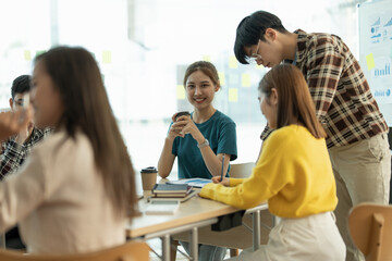 Fototapeta premium Young asian woman wokring in board room with her team to discussing idea fro startup project