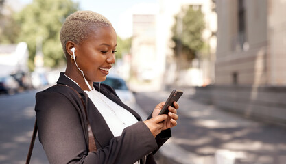 Got to select some songs to enjoy during my commute. Shot of a young businesswoman wearing...