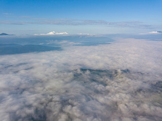 High flight above the clouds in the mountains. Aerial drone view.