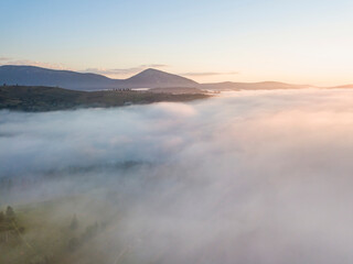 Sunrise over the fog in the Ukrainian Carpathians. Aerial drone view.