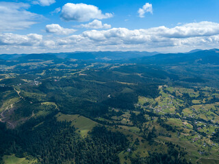 Green mountains of Ukrainian Carpathians in summer. Coniferous trees on the slopes. Aerial drone view.