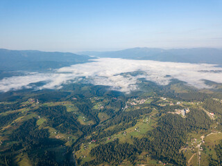 High flight in the mountains of the Ukrainian Carpathians. Fog in the valley. Aerial drone view.