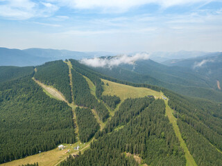 Green mountains of Ukrainian Carpathians in summer. Sunny day, rare clouds. Aerial drone view.