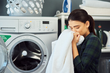 The smell of fresh laundry. Cropped shot of an attractive young woman smelling a freshly washed...