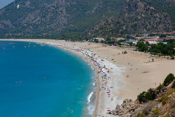 Amazing aerial view of Butterfly Valley in Fethiye Turkey. Summer landscape with mountains, green forest, azure water, sandy beach and blue sky in bright sunny day. Travel background. Top view. Nature