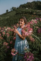 Thai woman is walking in flower field