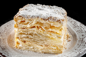 Napoleon cake, piece on a glass plate. Homemade cake, homemade in the kitchen.