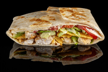 Juicy Mexican quesadilla with mozzarella, camembert and tomatoes. Isolated on black background.