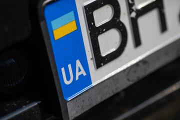 Shallow depth of field (selective focus) details with an Ukrainian plate number. - obrazy, fototapety, plakaty