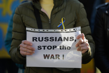 Details with the hands of an Ukrainian woman holding an anti war, pro Ukraine and anti Russia banner during an anti war protest in Bucharest, Romania