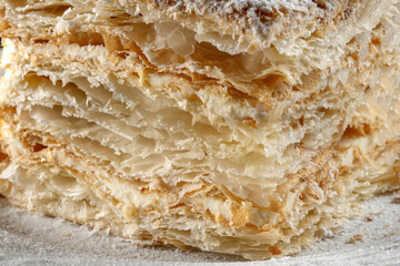 Napoleon cake, piece on a glass plate. Homemade cake, homemade in the kitchen.