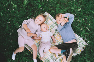 Children in nature. Preschool small kids play on green grass outdoors in summer. Siblings friendship. Holidays with family. Happy and healthy lifestyle. Minimalist style photo. - obrazy, fototapety, plakaty