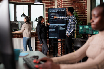 African american back end network developer explaining to coworker application lines of code. Team...