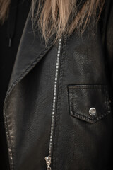 Fashionable girl in black stylish rock leather jacket with silver metal zipper and pocket, closeup....