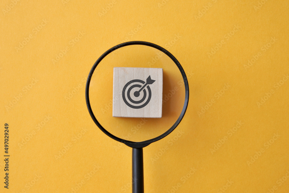 Poster a person points a magnifying glass at a target. symbol of the search for the purpose and meaning of 