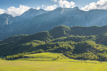 Obraz premium Beautiful mountain valley with gentle hills and agricultutal filds