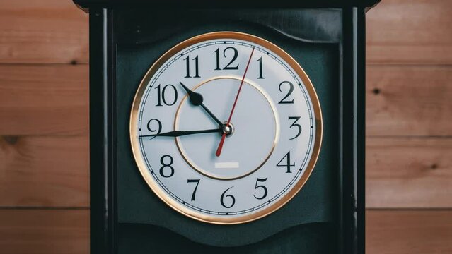 Vintage Clock Arrows Rotate at 11 PM or AM, Full Turn of Time Hands, Timelapse. Old Retro wall clock with second, minute, and hour hands on a white circular dial. An antique clock on wooden background