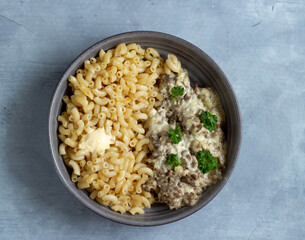 Pasta with meat and parsley in a gray plate. Top view.