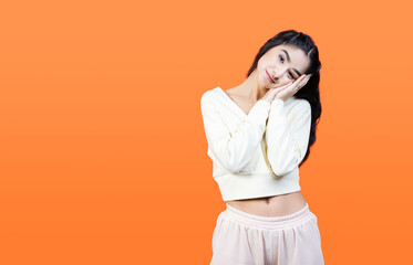 Drowsiness. Sleepy young woman on orange background with copy space.