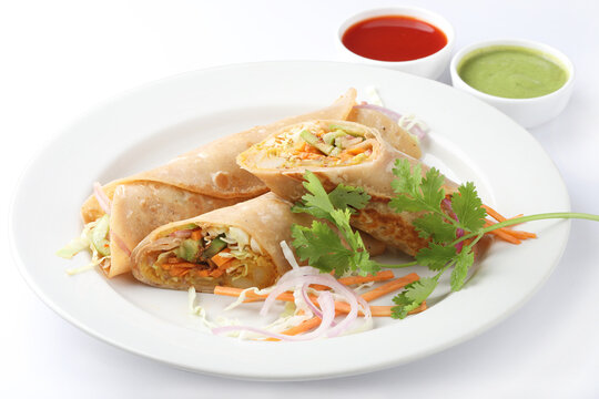 Indian Frankie Veg chapati Wrap / Kathi Roll, served in a plate with sauce & mint chutney. selective focus