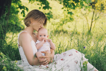 Beautiful mother and baby on nature. Young woman with her baby in harmony. Concept of natural...