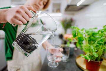 Girl pouring water from jar with shungite stones