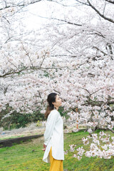 満開の桜の花と爽やかな女性