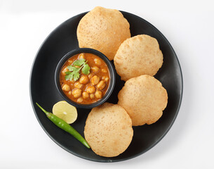Puri and Chole traditional Indian food 
Indian dish spicy Chick Peas curry also known as Chola/Chana Masala or commonly Chole, served served with fried puri or poori   - obrazy, fototapety, plakaty