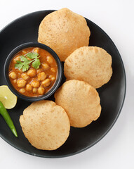 Puri and Chole traditional Indian food 
Indian dish spicy Chick Peas curry also known as Chola/Chana Masala or commonly Chole, served served with fried puri or poori  