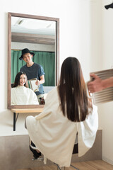 仕上がりを確認する男性美容師