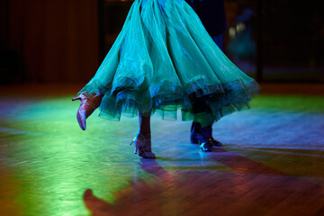 Close up of dancers feet. Ballroom dancers on the dance floor. A man in trousers, a woman in a magnificent ball gown. couple dancing on the floor.