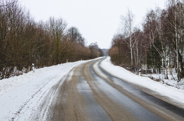 Asphalt road in winter on which slush and water. 