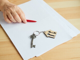 woman does not dare to sign documents for buying or renting an apartment. The house key lies on the...