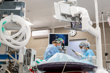 Two surgeons doing surgery on a man on a couch