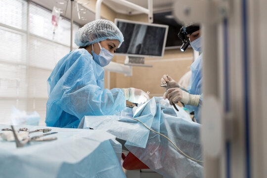 Surgeons in blue uniform operate on a man
