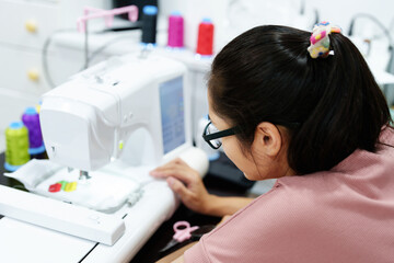 Embroidery, handicrafts, hobbies, SME business, family business, Portrait of Asian female designers are doing by designing patterns using automatic embroidery machines by customer order.