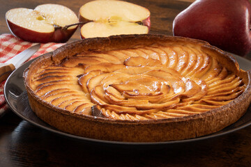 an apple pie with fruits on a wooden background