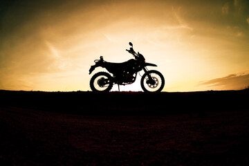 Obraz na płótnie Canvas Tourist motorcycle motocross silhouette Park on the mountain in the evening. adventure travel concept