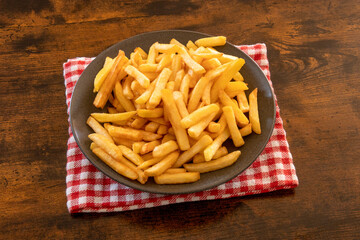 top view of a plate of french fries on a wooden table