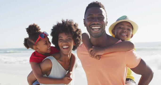 Portrait of smiling african american family embracing on sunny beach