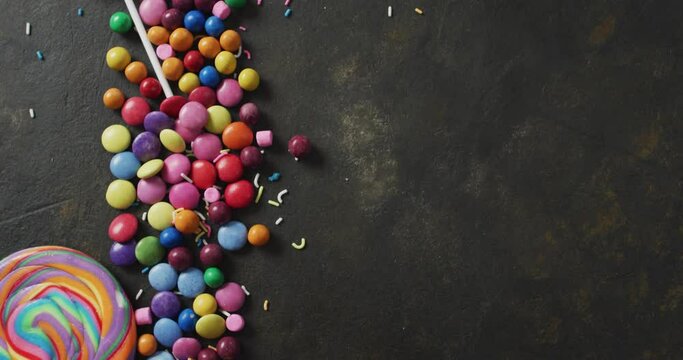 Video of colourful lentils and lollipop on grey background