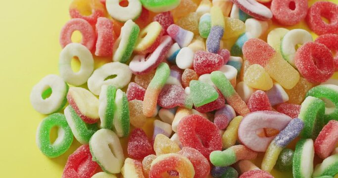 Video of colourful jelly candy on yellow background