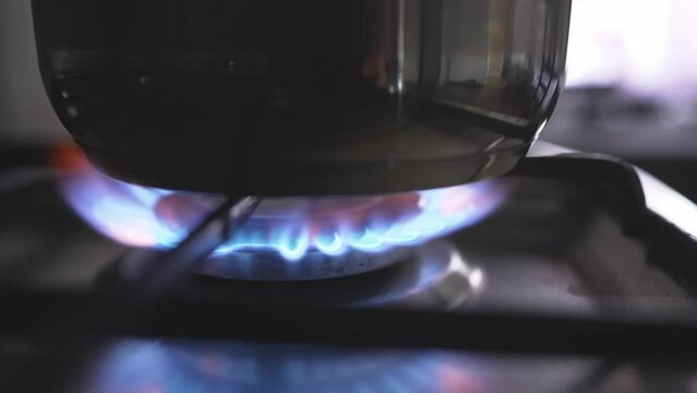 saucepan in a fire on the burner of the gas stove. A stove uses combustible or natural gas from the city gas network or liquefied gas as fuel. the energy crisis and rising energy prices. slow motion 