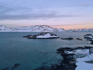 Islands in fjord in misty pink fog