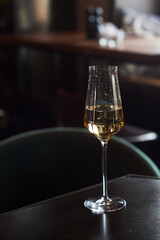 One glass of champagne, sparkling wine. Against the background of the side and garlands. Celebrating the new year.Loneliness.