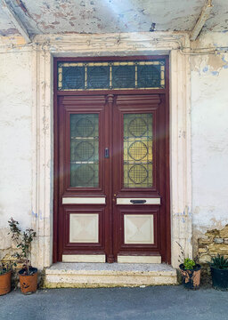 Old Burgund wooden door with glasses. Details Classic vintage door and potted plants near the wall