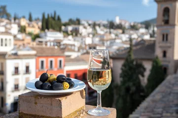 Fotobehang Tasting of Spanish sweet and dry fortified Vino de Jerez sherry wine and olives with view on roofs and houses of old andalusian town © barmalini